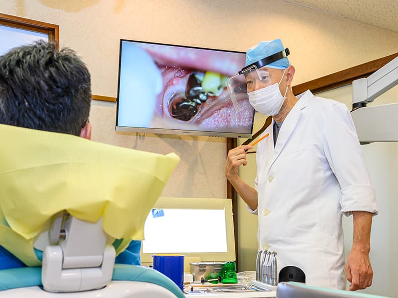埼玉県上尾市の三井歯科医院の院長萩原寛司先生が患者さんに治療説明
